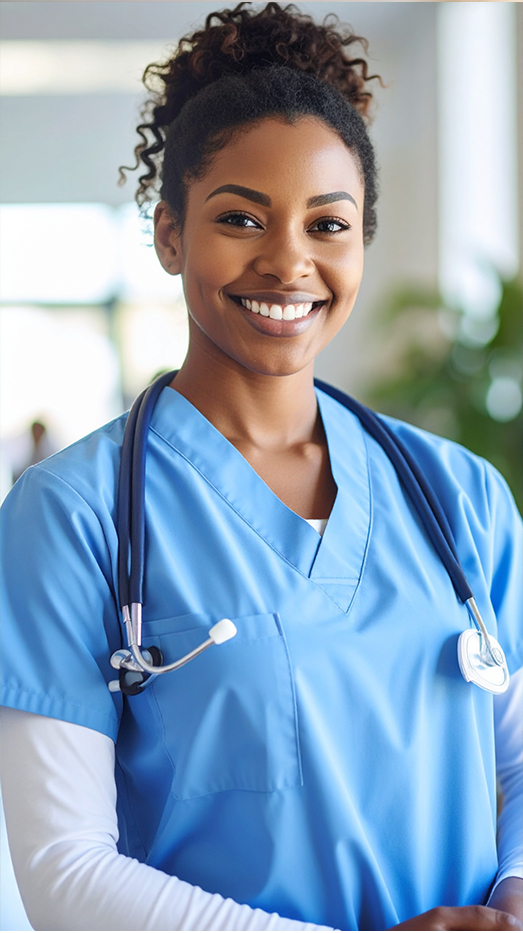 Smiling healthcare professional wearing blue scrubs and stethoscope.