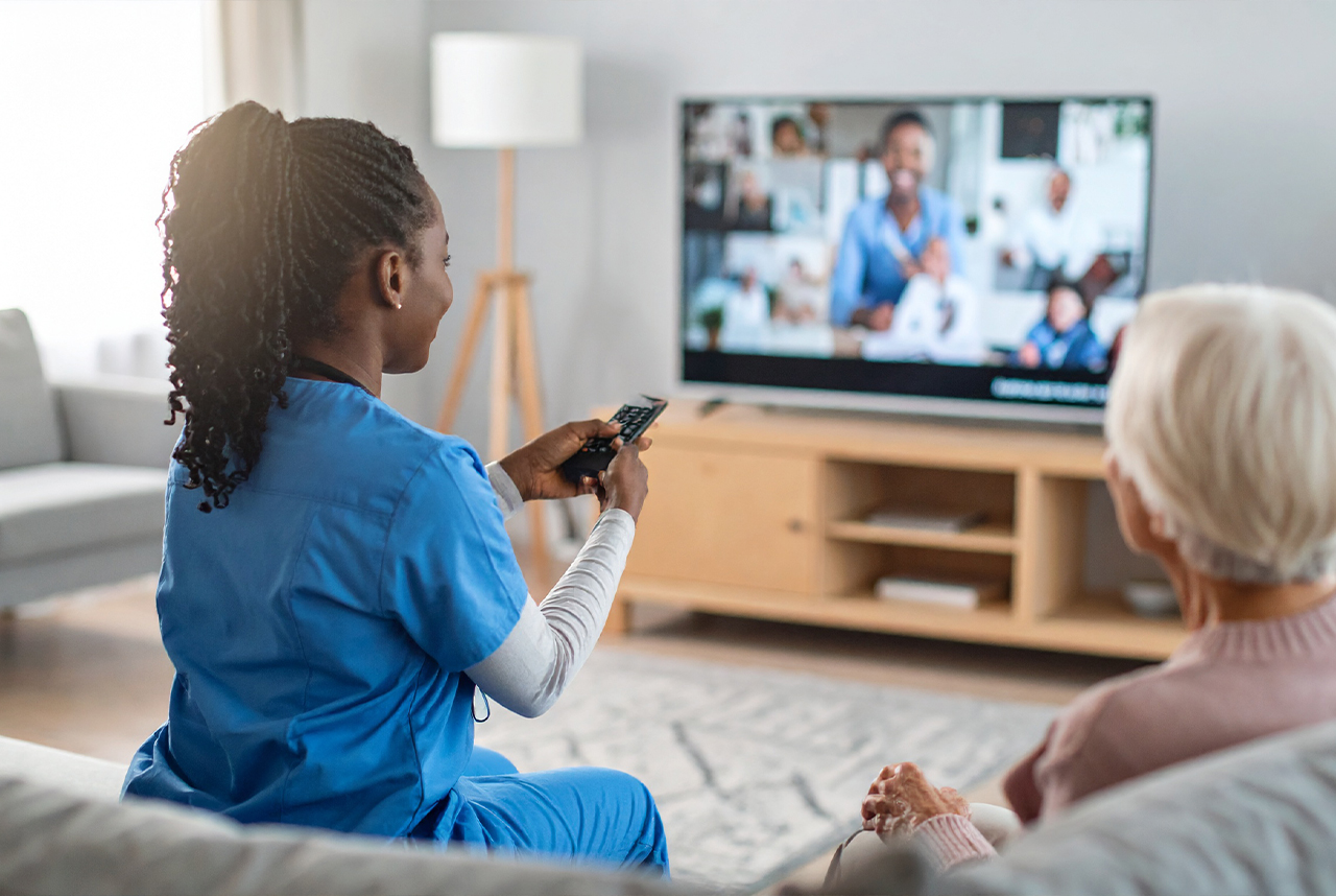Healthcare worker watching TV in scrubs, holding a remote.